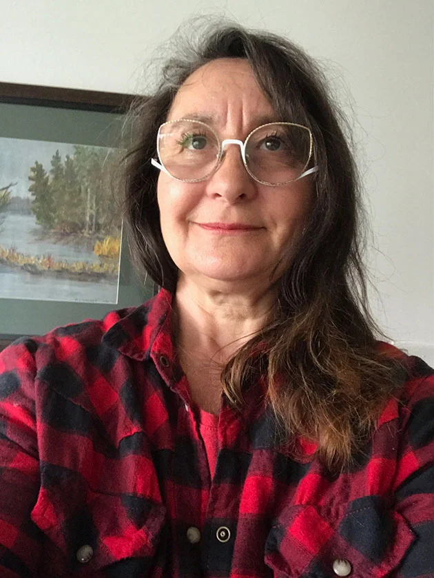 Portrait of Margaret Danda-Daoust, a registered Ontario Speech-Language Pathologist wearing a red plaid shirt.